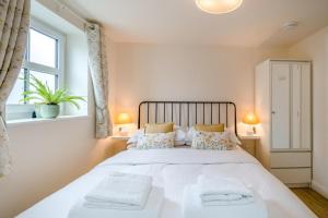 a bedroom with a large white bed with two towels at 1 Bed in Lytham St. Annes oc-86044 in Saint Annes on the Sea