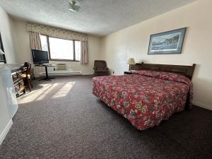a hotel room with a bed and a television at Auberge Eldo Inn in Blind River +16 photos