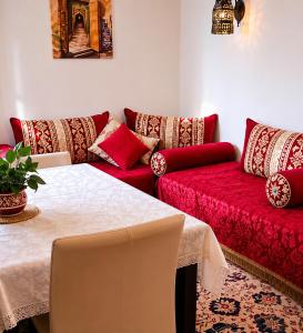 a living room with a red couch and a table at Dar Amine in Rabat