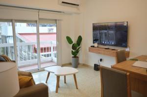 a living room with a couch and a tv and a table at Las Heras in Bahía Blanca