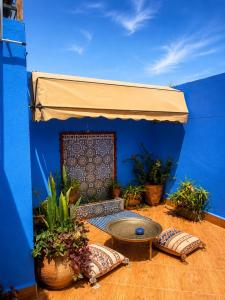 a blue wall with a table and some potted plants at Dar Amine in Rabat