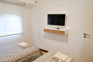 a white room with a bed and a tv on a wall at Las Heras in Bahía Blanca