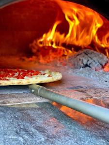 a pizza being cooked in a fire oven at The Lemon Garden Escape in Meta