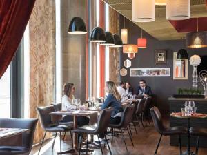 a group of people sitting at tables in a restaurant at Mercure Lyon Centre - Gare Part Dieu in Lyon