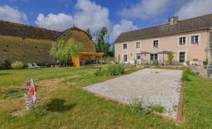 a large yard with a house and a building at Le clos de la ferme in Chervey