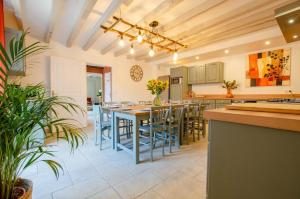 an open kitchen with a large table and chairs at Le clos de la ferme in Chervey