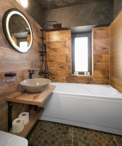 a bathroom with a tub and a sink and a mirror at Lapusneanu Central Apartments in Iaşi
