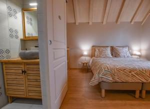 a bedroom with a bed and a dresser with a mirror at La ferm'hier in Balnot-sur-Laignes