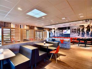 a restaurant with tables and chairs and a piano at ibis Les Herbiers in Les Herbiers +47 photos