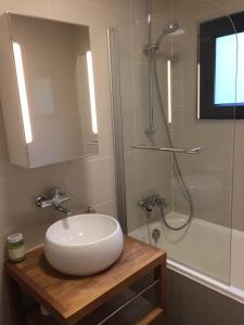 a bathroom with a white sink and a shower at Cozy chalet with panoramic views in Leysin in Leysin +11 photos