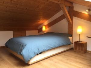 a bedroom with a blue bed and two lamps at Cozy chalet with panoramic views in Leysin in Leysin