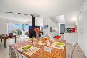 a kitchen and dining room with a wooden table at Villa Mondacce with Jacuzzi & Lake Views in Minusio