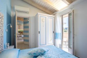a bedroom with a blue bed and a balcony at Blue Moon in Castelsardo