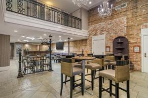 eine Lobby mit Tischen und Stühlen und einer Backsteinmauer in der Unterkunft Best Western Plus St. Christopher Hotel in New Orleans