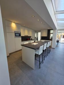 a kitchen with a large island in the middle of a room at Huisje Well Tevree in Roesbrugge-Haringe