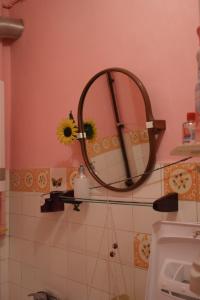a bathroom with a mirror on a pink wall at Feel The Old Socialist Style Apartment in Krakow