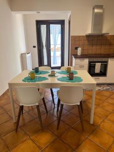 a white table and chairs in a kitchen with a table and chairsktop at I Pantani in Schisò