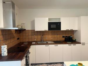 a kitchen with white cabinets and a microwave at I Pantani in Schisò +16 photos