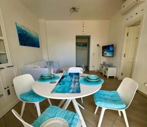 a living room with a white table and chairs at Blu Suite Ostia in Lido di Ostia