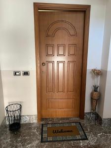 a wooden door with a welcome mat in front of it at I Pantani in Schisò
