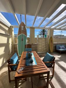a patio with a table and chairs and a surfboard at Blu Suite Ostia in Lido di Ostia