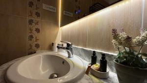 a bathroom with a sink and a vase of flowers at Nefeli Boutique Hotel in Agios Kirykos +91 photos
