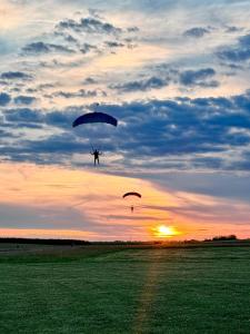 a person is flying with two parachutes in the sky at Zserbó lak in Kisapostag