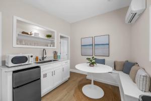 a white kitchen with a table and a microwave at Dune Drift in Cocoa Beach