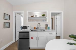 a white kitchen with a sink and a microwave at Dune Drift in Cocoa Beach