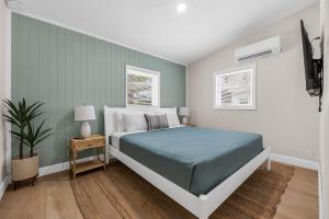 a bedroom with a bed and a night stand with a plant at Dune Drift in Cocoa Beach