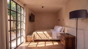 a bedroom with a bed and a large window at Casa Chati Hostal Boutique in San Cristóbal de Las Casas