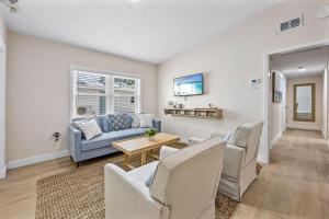 a living room with a couch and chairs and a table at Breakwater Bungalow in Cocoa Beach