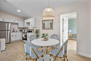 a kitchen and dining room with a table and chairs at Breakwater Bungalow in Cocoa Beach