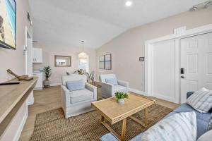 a living room with a couch and two chairs and a table at Breakwater Bungalow in Cocoa Beach