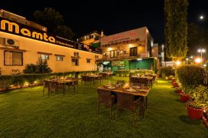 a restaurant with tables and chairs in a yard at night at Hotel New Mamta by SSH 350 Metres from Nakki Lake in Mount Ābu +40 photos