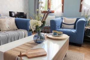 a living room with a vase of flowers on a coffee table at Le Maluthina Maison Familiale au Hourdel entre Mer & Nature in Cayeux-sur-Mer