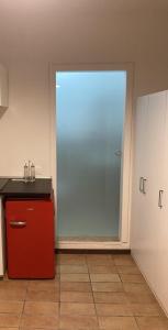 a kitchen with a red refrigerator and a window at Monolocale Cerreto Laghi in Cerreto Laghi