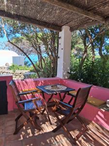 a patio with a table and chairs and a bench at dammuso rosa in Pantelleria