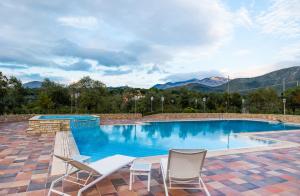 a swimming pool with chairs and mountains in the background at Lilium B&B Villa Patrizia - Con piscina e parcheggio by Mamo Florence in Itri