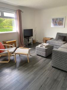 a living room with a couch and a chair at Almondbank Cottage 8 miles from Portree 2 bedrooms sleeps 3 adults in Skeabost