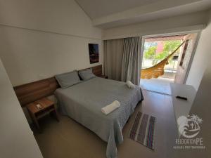 a bedroom with a bed and a large window at Vila Sol Serrambi in Porto De Galinhas +57 photos