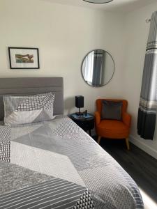 a bedroom with a bed and a chair and a mirror at Almondbank Cottage 8 miles from Portree 2 bedrooms sleeps 3 adults in Skeabost