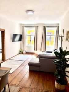 a living room with a couch and two windows at Apartmán Růženka Písek in Písek