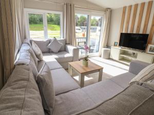 a living room with a couch and a tv at The Oaks 3 Bedrooms in Northwich