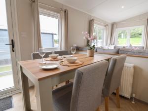 a dining room with a wooden table and chairs at The Oaks 3 Bedrooms in Northwich