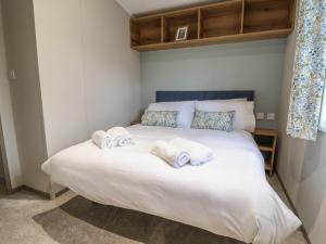 a bedroom with a bed with towels on it at The Oaks 3 Bedrooms in Northwich