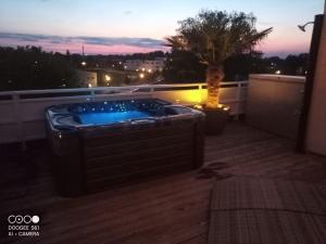 a jacuzzi tub on a balcony at night at Penthouse Seebrise in Großräschen