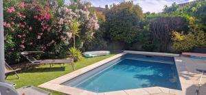 a swimming pool in a yard with flowers at Le cabanon du plaisir in Montpellier