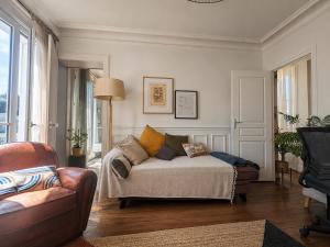 a living room with a bed and a couch at Charmant appartement au cœur de Paris in Paris
