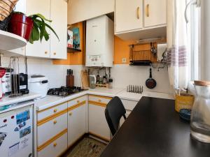 a kitchen with white cabinets and a black counter top at Charmant appartement au cœur de Paris in Paris